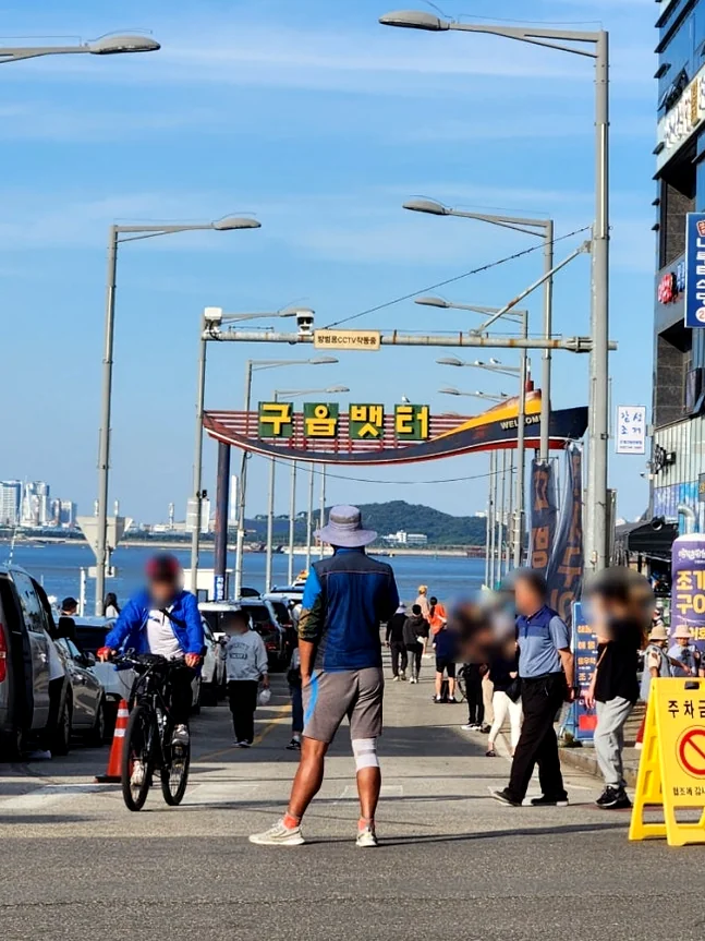 A unique rooftop garden installation adorned with numerous baskets of pink apples and a large, verdant tree, offering a distinct lifestyle ambiance against a city and sea backdrop at dusk. - Badaap Terrace: Yeongjongdo's Premier Oceanfront Cafe Experience