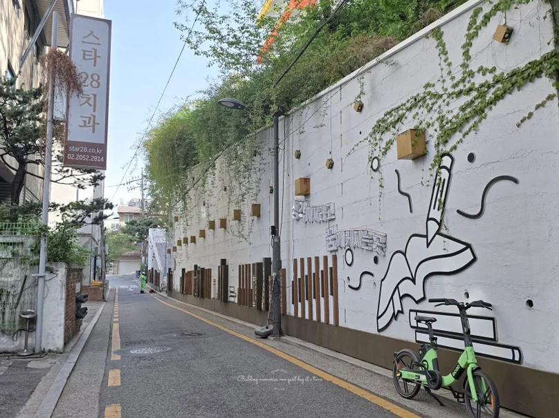 A charming exterior wall mural and a bicycle path leading to the library, showcasing the artistic and pedestrian-friendly atmosphere of the surrounding Gangnam neighborhood. - Literary Luxury in Gangnam: The 2026 Great Children’s Day Festival at the National Library for Children and Young Adults