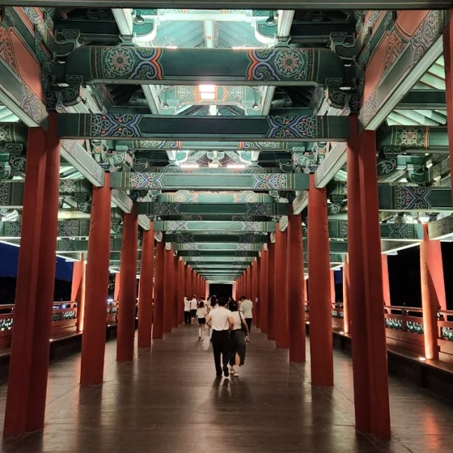 A long, illuminated walkway within the Woljeonggyo Bridge, showcasing the traditional wooden pillars and ornate ceiling patterns, inviting travelers to step into a journey through time and architectural beauty. - Gyeongju Woljeonggyo: A Luminous Echo of Silla's Grandeur in 2026