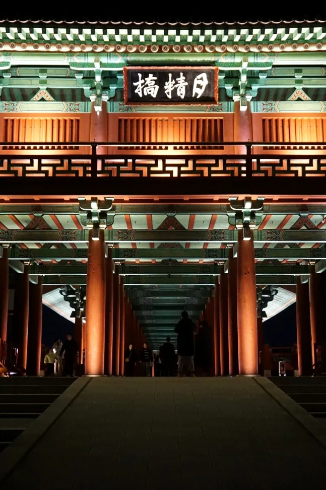 Woljeonggyo Bridge captured from a dynamic low-angle perspective at night, emphasizing its imposing structure and the warm glow emanating from its grand entrance, drawing visitors into its historical embrace. - Gyeongju Woljeonggyo: A Luminous Echo of Silla's Grandeur in 2026