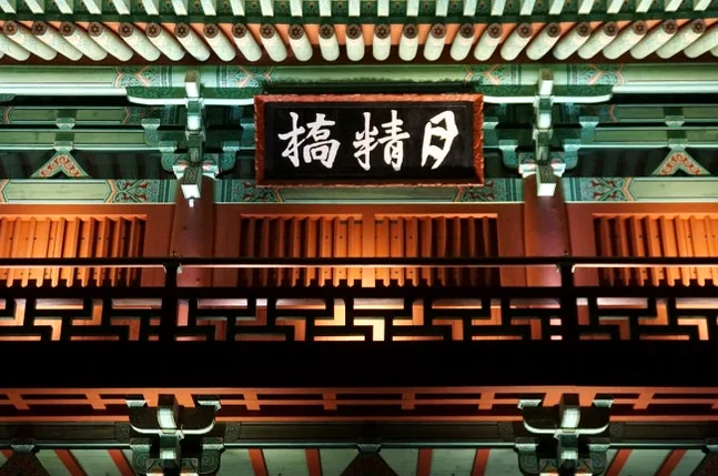 A horizontally framed detail of the '月精橋' signboard and the ornate traditional roof section at night, highlighting the exquisite craftsmanship and decorative elements that define Korean traditional architecture. - Gyeongju Woljeonggyo: A Luminous Echo of Silla's Grandeur in 2026