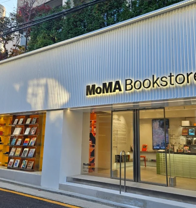A wide shot of MoMA Bookstore Seoul's pristine white exterior, highlighting its clean architectural lines and inviting glass entrance from a balanced street perspective, hinting at the sophisticated interior.</div - MoMA Bookstore Seoul: A Curated Sanctuary for Art and Design
