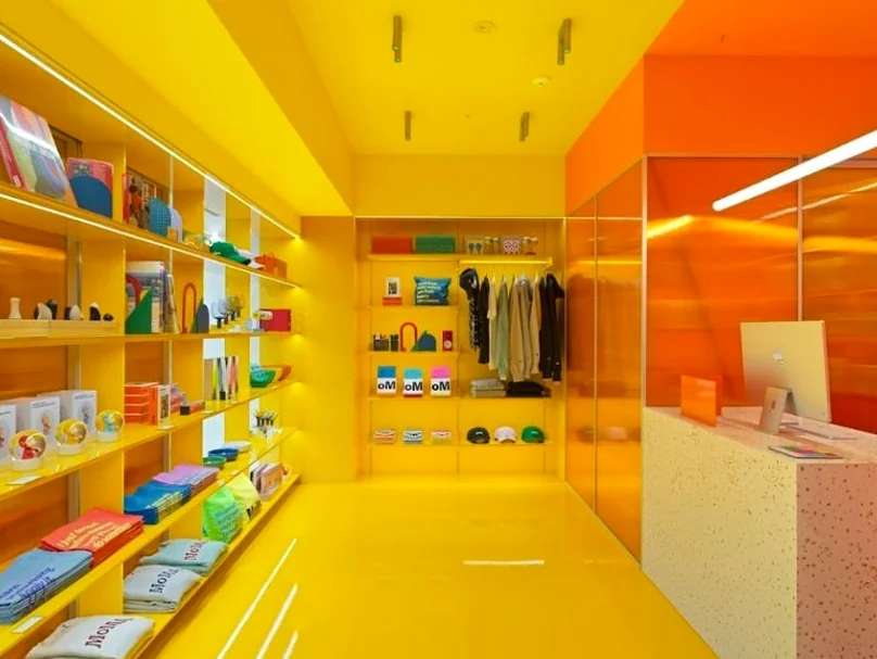 A vibrant and energetic section of MoMA Bookstore Seoul, characterized by bold yellow and orange walls, showcasing a curated selection of colorful merchandise and books, reflecting its contemporary design ethos and playful spirit. - MoMA Bookstore Seoul: A Curated Sanctuary for Art and Design
