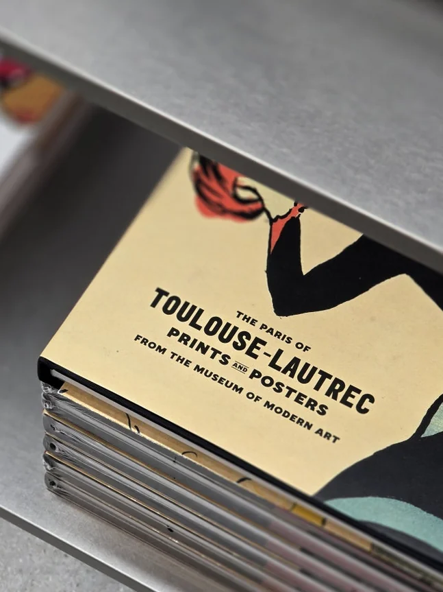 A meticulously stacked display of books on 'Toulouse-Lautrec: Prints & Posters', reflecting the bookstore's dedication to showcasing influential artists and delving into various art movements. - MoMA Bookstore Seoul: A Curated Sanctuary for Art and Design