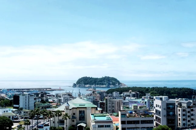 The prominent exterior of Deokseongwon, a celebrated Chinese restaurant, featuring its distinctive black granite facade and the elegant Korean and Chinese characters announcing its name, capturing its stately presence on a bright day. - Jeju Heritage Gastronomy: The Timeless Allure of Deokseongwon Seogwipo