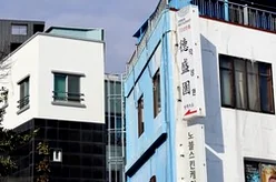 The minimalist interior lighting of Deokseongwon, casting a warm glow over the wooden tables and creating an intimate atmosphere during the late afternoon. - Jeju Heritage Gastronomy: The Timeless Allure of Deokseongwon Seogwipo