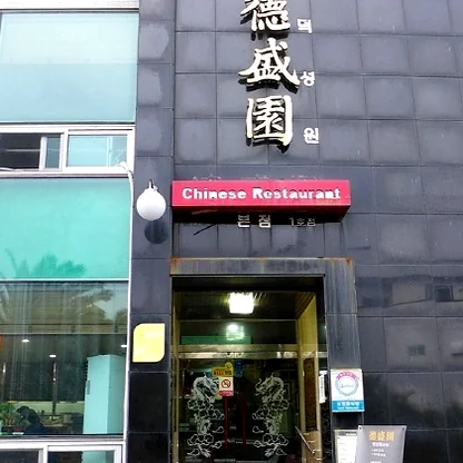 A view from a window seat at Deokseongwon, overlooking the quiet streets of Seogwipo as the sun begins to set over the island. - Jeju Heritage Gastronomy: The Timeless Allure of Deokseongwon Seogwipo