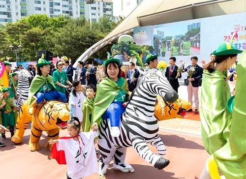Vibrant character mascots interacting with families under the spring sun - Narrative Arc at Banghwa Neighborhood Park: The 2026 Gangseo Fairy Tale Festival