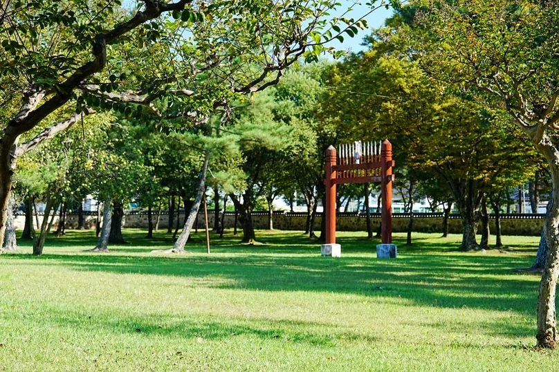 Sun-drenched pathways through the historic parkland, showing the vast spatial layout that offers a peaceful retreat for modern-day wanderers. - Gyeongju Oreung: The Architectural Silence of Silla’s Sacred Five