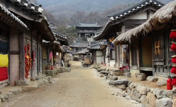 A sprawling view of the low-class residential area with thatched roofs and stone walls - Cinematic Grandeur: Architectural Time Travel at Yongin Daejanggeum Park