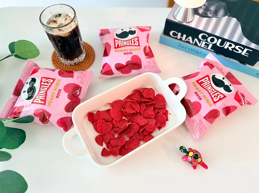 白いボウルいっぱいに盛られた鮮やかなハート型のチップスの周りに、アーティスティックに配置されたプリングルズ・ハート・ミニ・ローズ의 패키지. - 韓国限定・世界初の上陸。メガボックスとGSザ・フレッシュで出会う「プリングルズ・ハート・ミニ・ローズ」の誘惑