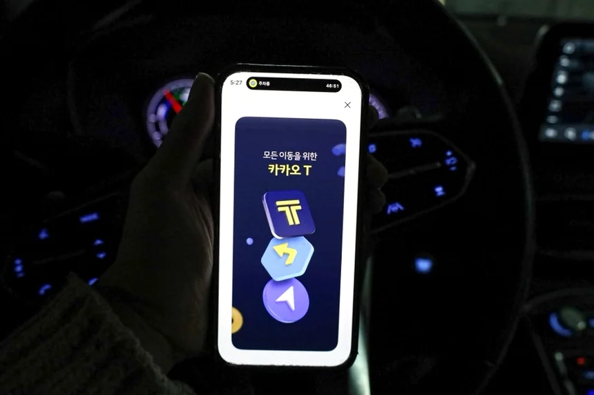 alt: 車内のスマートフォン画面に輝くカカオTのゴールデンロゴ
</div - 江南・新沙洞の洗練をスマートに、カカオT（Kakao T）で極める都市移動の最適解