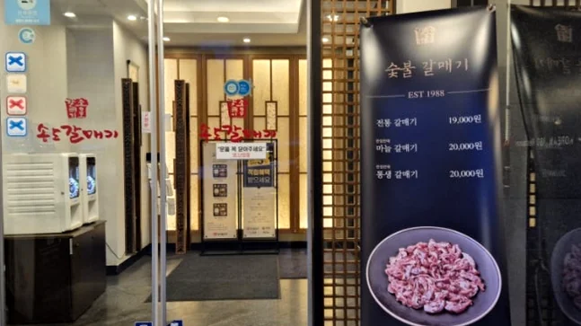 alt="ゲストを温かく迎えるヘリテージブランドのシグネチャーエントランス" - 1988年から続く伝統の味、松島カルメギ本店で堪能する至高のガストロノミー