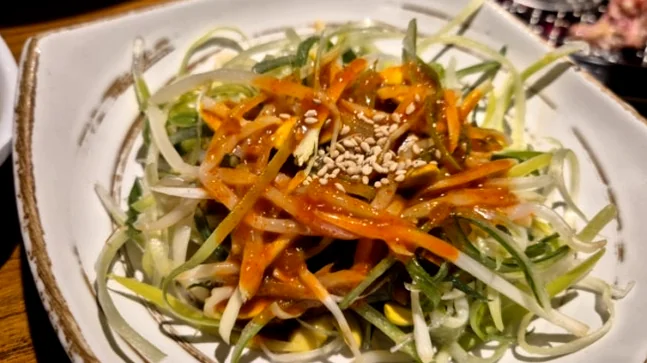 alt="肉의旨味を引き立てるシャキシャキとした食感の味付けネギサラダ" - 1988年から続く伝統の味、松島カルメギ本店で堪能する至高のガストロノミー