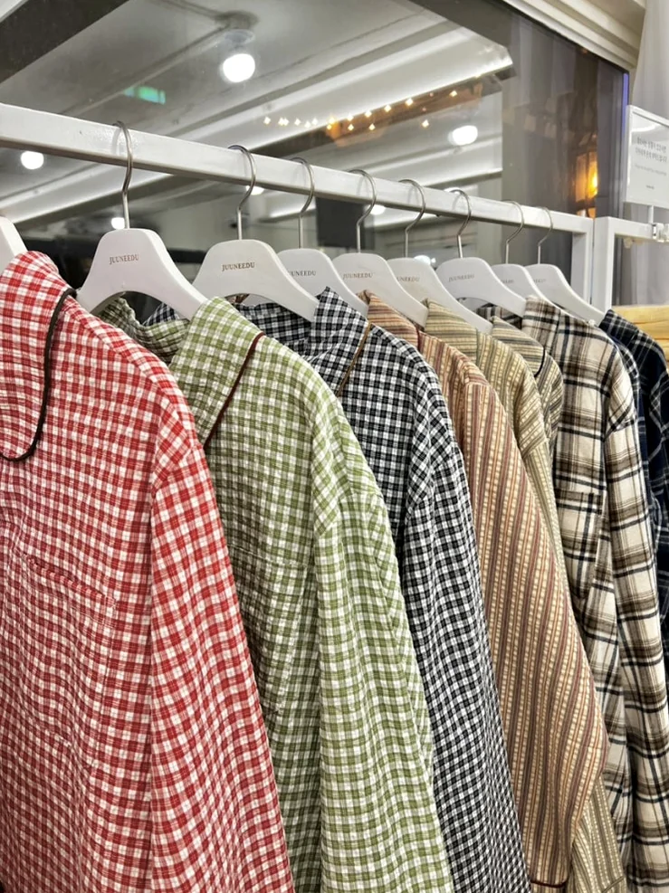 A thoughtfully curated display table within the showroom, featuring neatly folded pajamas, decorative lamps, and a chic handbag, inviting customers to explore the collection with a sense of refined comfort. - Beyond Comfort: The Curated Pajama Sanctuary of Yeonnam-dong, Juuneedu Showroom