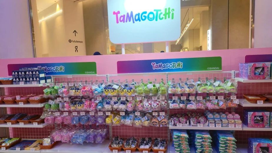 Rows of colorful Tamagotchi merchandise neatly displayed on pink shelves, showcasing a variety of plush toys and accessories for fans. - Lotte World Jamsil: The Ultimate Multi-Layered Fantasy Realm in Seoul