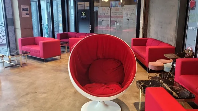 Stylish relaxation space with uniquely designed red chairs and comfortable sofas - Coastal Crust and Artisanal Calm: The Definitive Guide to Aewol Bread Factory Jeju