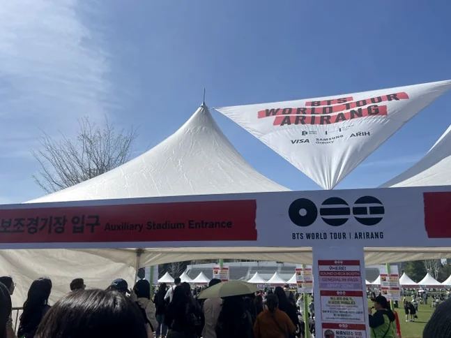 White hospitality tents and official signage marking the entrance to the Arirang World Tour venue - BTS Arirang World Tour: A Masterpiece of Cultural Heritage and Global Modernity