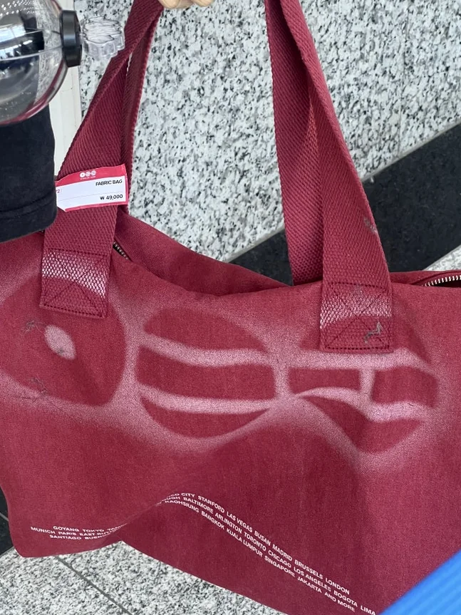 A detailed shot of the deep red official tote bag featuring the Arirang pattern - BTS Arirang World Tour: A Masterpiece of Cultural Heritage and Global Modernity