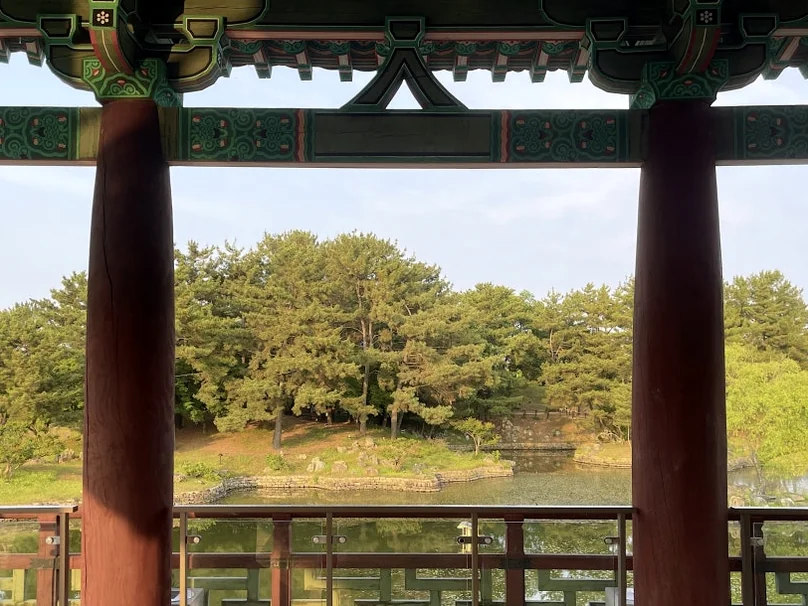 A picturesque view of Wolji Pond framed naturally between the traditional wooden pillars of the palace architecture - Beyond the Moonlight: The Timeless Allure of Gyeongju Donggung Palace and Wolji Pond