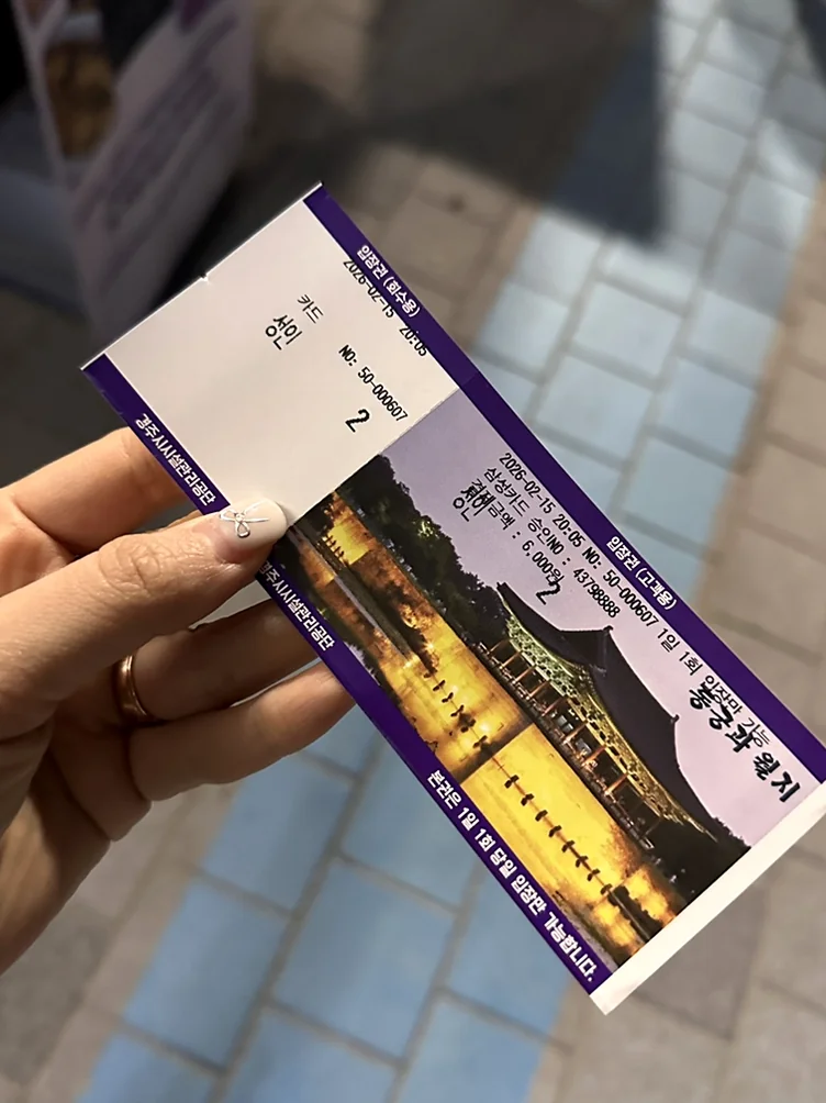 A physical photograph of a visitor holding an admission ticket as a tangible souvenir of the journey - Beyond the Moonlight: The Timeless Allure of Gyeongju Donggung Palace and Wolji Pond