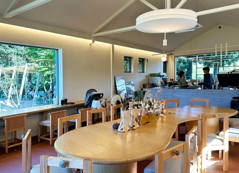 통창을 통해 외부의 자연을 내부로 끌어들인 감각적인 인테리어와 테이블 배치 - 済州島の静寂を歩く。ハルラ山の麓に佇む秘密の庭園カフェ「ダムソヨ（DAMSOYO）」完全ガイド ✨