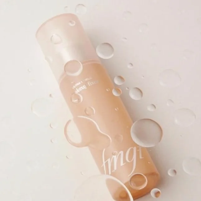 fmgt 미스트 또는 액상 제품의 단독 패키지 컷. 제품 위로 맺힌 물방울이 촉촉한 제형감을 암시하며, 간결한 흰색 배경과 어우러져 하이엔드 라이프스타일 매거진의 미적 기준에 부합합니다. - K-Beautyの最新トレンド！THE FACE SHOP fmgtで叶える自然体メイク術
