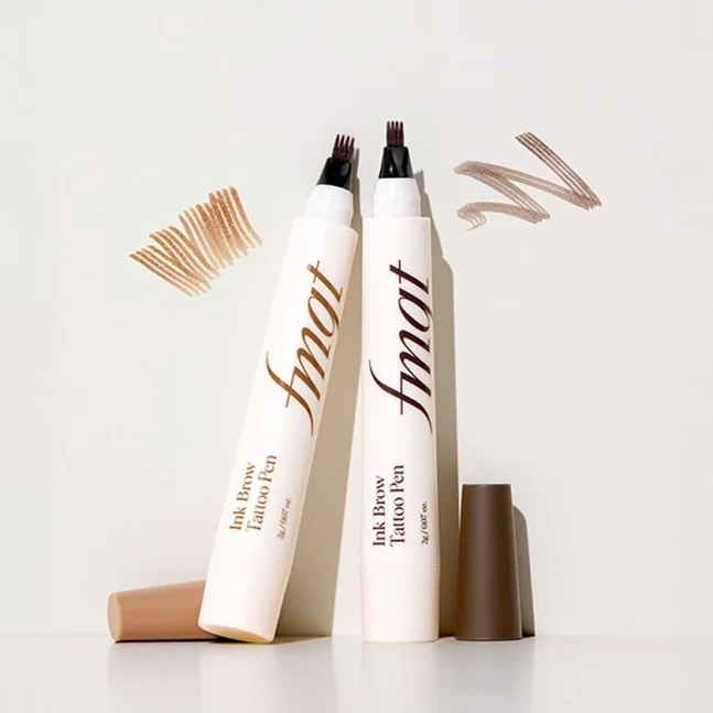 fmgt 잉크 브로우 타투펜 2종을 정갈하게 배치하고 그 옆에 발색 스와치를 함께 보여주는 감각적인 컷. 자연광을 활용한 미니멀한 무드와 'Hanako' 스타일의 플랫 레이 구도를 잘 따랐습니다. - K-Beautyの最新トレンド！THE FACE SHOP fmgtで叶える自然体メイク術