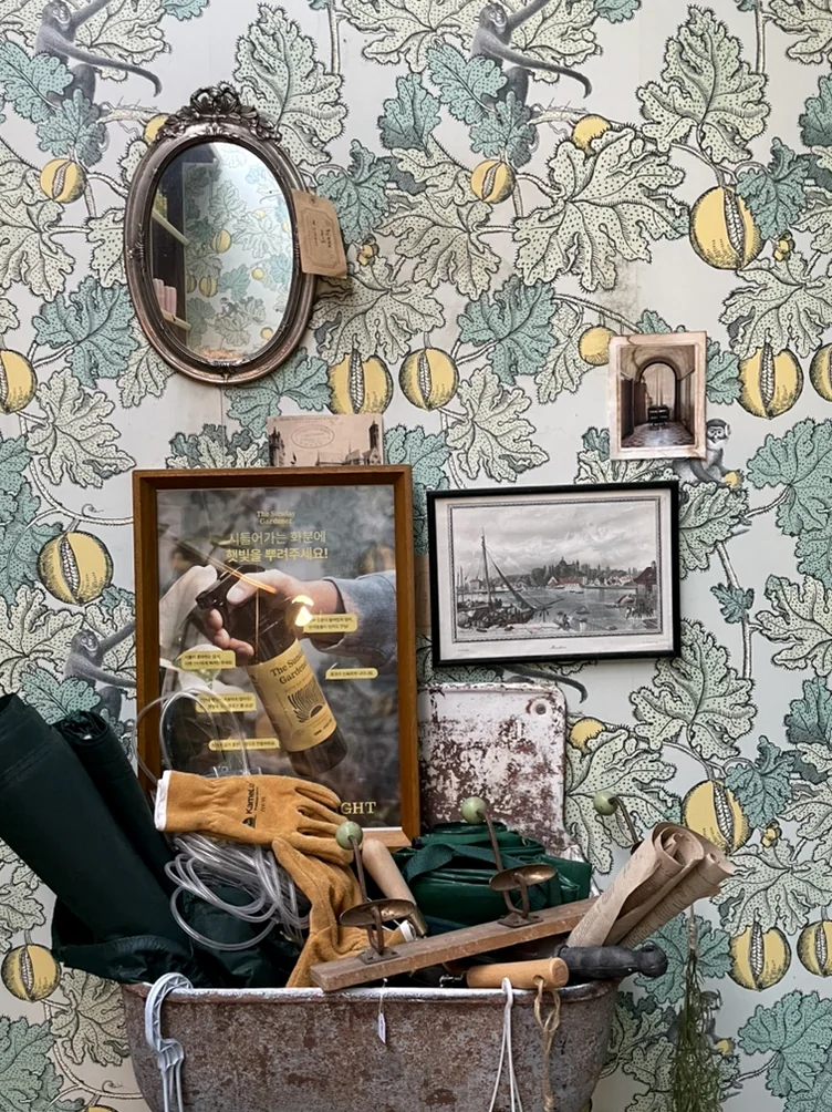 Floral wallpaper with a small mirror and garden tools in a metal basin - 2026年ソウル・新堂洞(シンダンドン)で見つけた、パリの記憶。ライフスタイルショップ『セシル・アンド・セドリック(Cecile Cedric)』へ