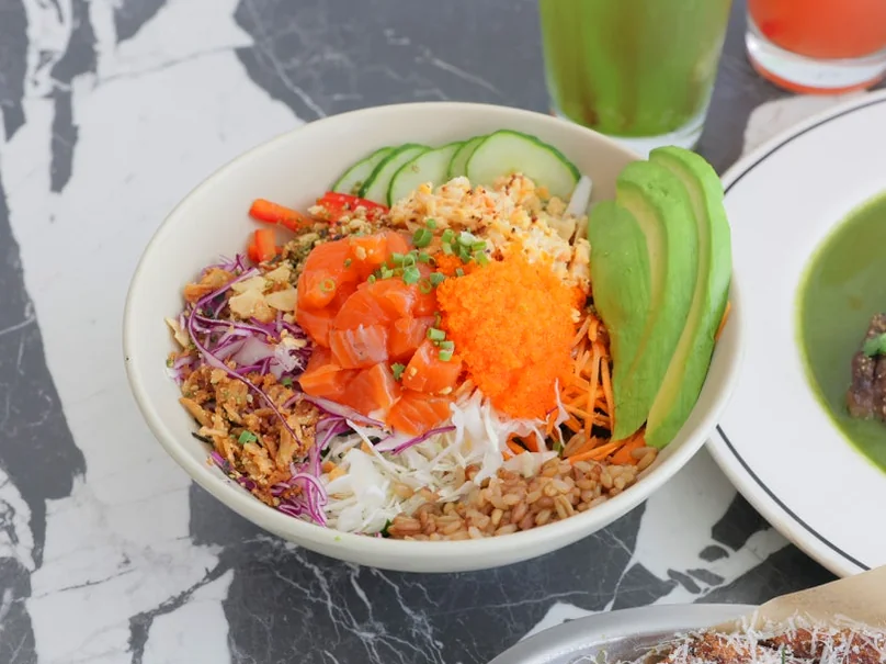 A close-up of a poke bowl with avocado, salmon roe, and various toppings, with a 'LITTLENECK' branded cup in the background. - 漢南洞のアイコン 'LITTLENECK' 完全攻略。プレミアムな週末ブランチと最新ショールーム巡り ✨