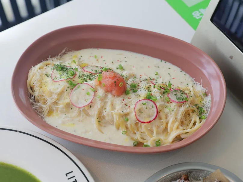 A close-up of a cream pasta dish with salmon roe and radish slices in an oval bowl. - 漢南洞のアイコン 'LITTLENECK' 完全攻略。プレミアムな週末ブランチと最新ショールーム巡り ✨