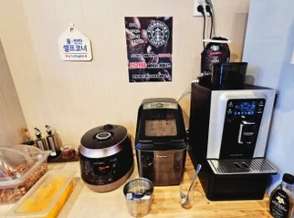 Self-service station with a rice cooker, coffee machine, and small containers - ソウル・新堂洞の路地裏で見つけた、心まで満たされるシビ辛の聖地：新羅坊（シルラバン）マラタン