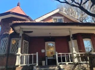 Stone monument with a detailed religious relief sculpture and Korean text, positioned in the foreground with Yakhyun Catholic Church in the background. - ソウル駅の裏側に眠る130年の物語。中林洞・薬峴聖堂(ヤッキョンソンダン)で巡る歴史と美学の散歩道
