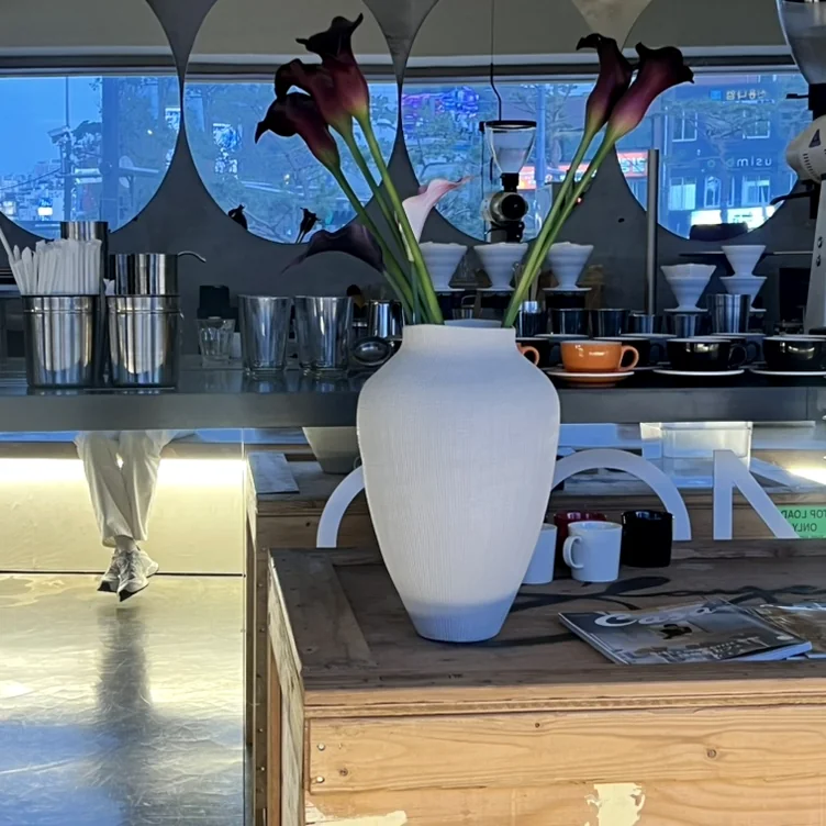 White ceramic vase with purple flowers on a wooden crate - 春のソウル、漢南洞（ハンナムドン）で見つける旬の『K-Fashion』と洗練された日常の楽しみ方