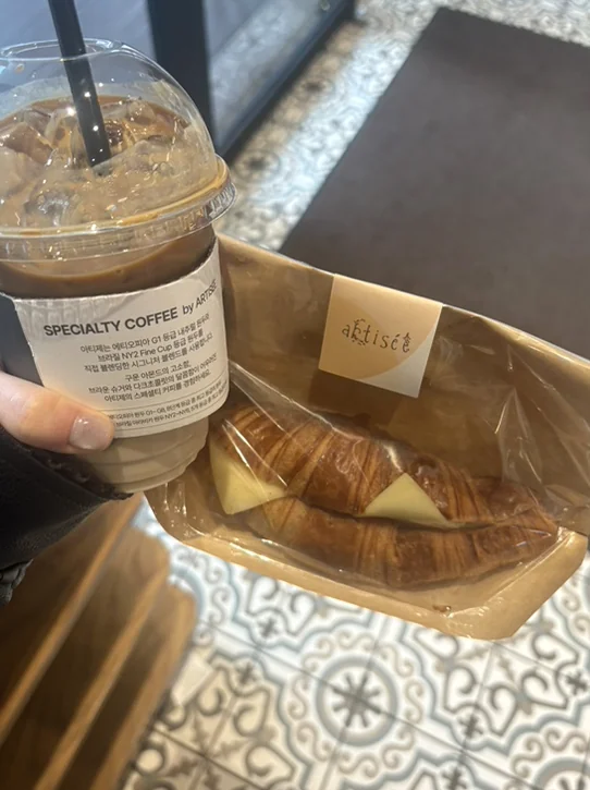 Take-out coffee cup and a croissant in a paper bag - 春のソウル、漢南洞（ハンナムドン）で見つける旬の『K-Fashion』と洗練された日常の楽しみ方