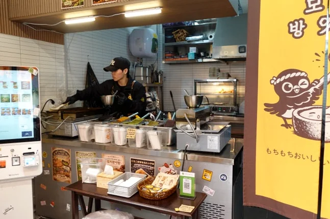 Interior view of the shop kitchen and ordering kiosk with an employee working. - A Masterclass in Gluten-Free Snacking: Mochi Taiyaki at Mojjibangatgan Yeonnam