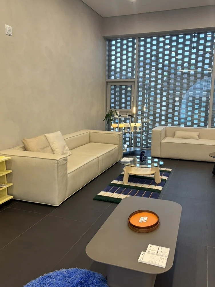 White sofas and a blue rug in a minimalist showroom - 漢南洞の美学に触れる。フレグランスブランド 'Pesade' と感性を磨くソウル散策ガイド