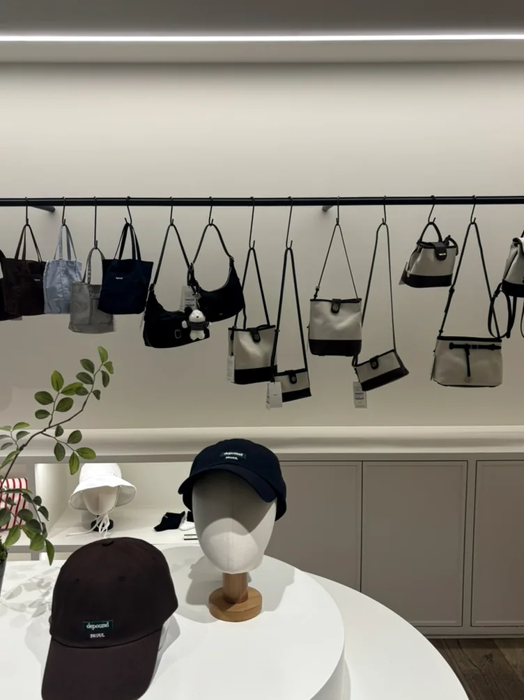 Black and white handbags hanging on a minimalist display rack - 漢南洞の美学に触れる。フレグランスブランド 'Pesade' と感性を磨くソウル散策ガイド