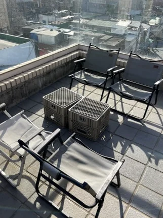 Grey camping chairs and plastic crates arranged on an outdoor rooftop terrace - 郵便局がカフェに？ソウル・新堂洞(シンダンドン)の隠れ家『メールルーム』で体験する非日常