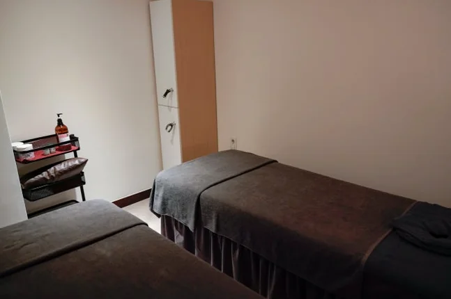 Spa room with two dark massage beds and a light-colored cabinet - ソウル新堂洞(シンダンドン)で見つける極上タイマッサージ:カシアタイでの癒し体験 ✨
