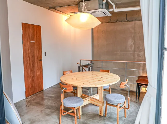 Room with a round wooden table and four chairs, illuminated by a pendant light - ソウル新堂洞(シンダンドン)で見つける極上タイマッサージ:カシアタイでの癒し体験 ✨