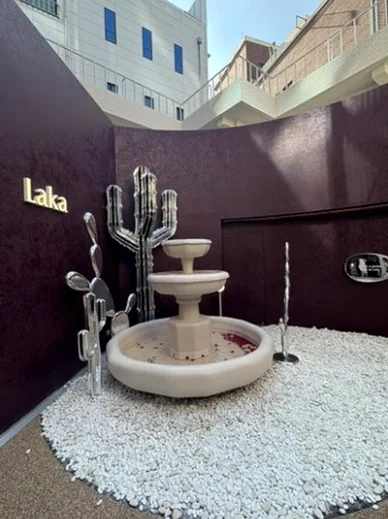 Small stone fountain in a minimalist courtyard with a gold Laka logo and silver cactus sculptures - ジェンダーニュートラルな美の聖地。聖水洞 'ラカ (Laka)' フラッグシップストア完全ガイド