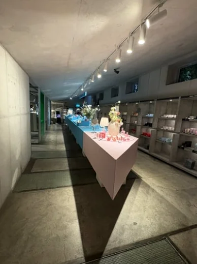 Sleek interior showroom with long triangular display tables and concrete walls - ジェンダーニュートラルな美の聖地。聖水洞 'ラカ (Laka)' フラッグシップストア完全ガイド