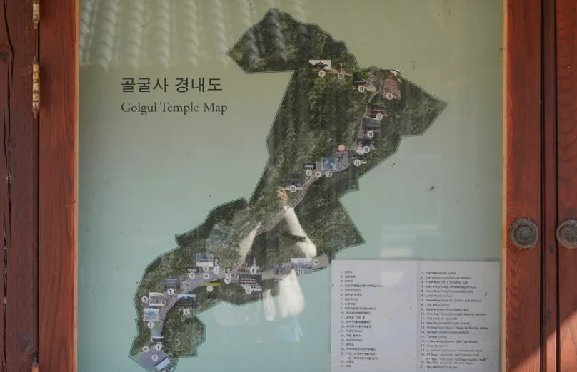 A wooden framed map showing the layout and paths of the Golgulsa Temple grounds - 慶州「骨窟寺（コルグルサ）」：1500年の時を刻む石窟寺院と、身心を整える「禅武道」の聖地へ