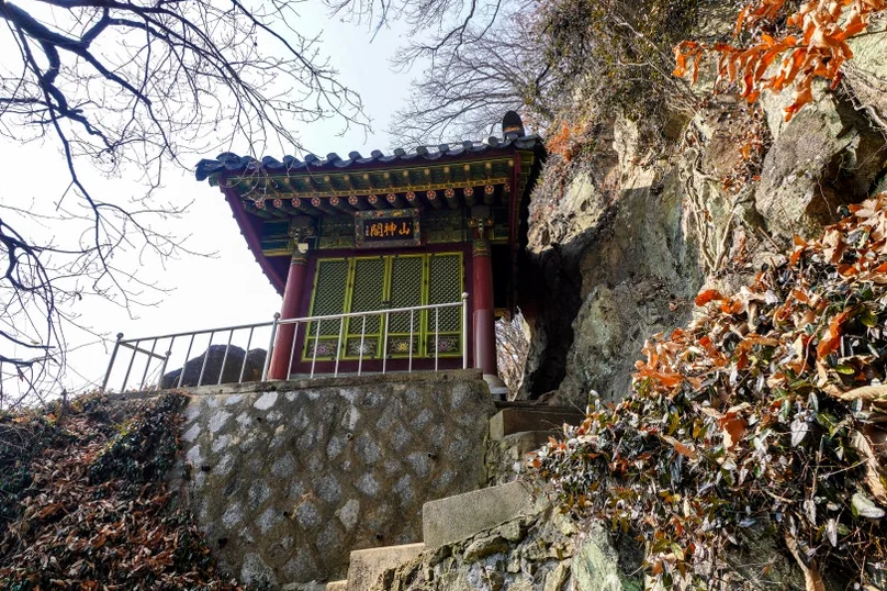 A traditional Korean temple building with a dark tiled roof and yellow walls, situated on a stone platform on a steep, rocky incline. - 全州(チョンジュ)西古寺(ソゴサ)で心癒すテンプルステイ体験：静寂の中で見つける本当の自分