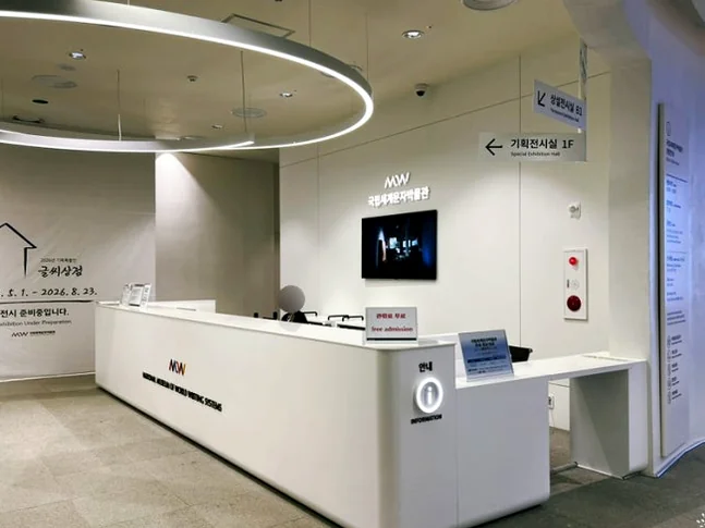 A long, white reception desk with modern lighting. - 仁川 松島：世界の文字を巡る旅へ！国立世界文字博物館で知的好奇心を刺激する一日を
