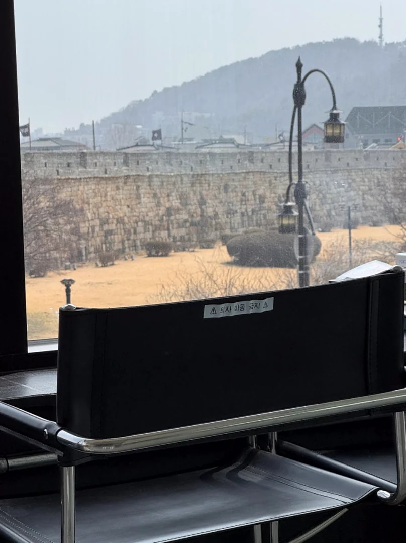 黒いフレームのチェアに座り、城郭の情景に浸るひととき - 水原（スウォン）の城郭を借景に。モダンな空間と絶品スイーツが奏でる「Sole Street（ソルストリート）」の誘惑 ✨
