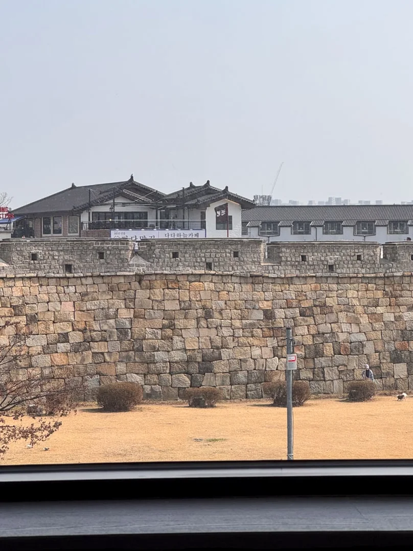 窓枠越しに広がる城郭と水原の街並みのノスタルジックな風景 - 水原（スウォン）の城郭を借景に。モダンな空間と絶品スイーツが奏でる「Sole Street（ソルストリート）」の誘惑 ✨