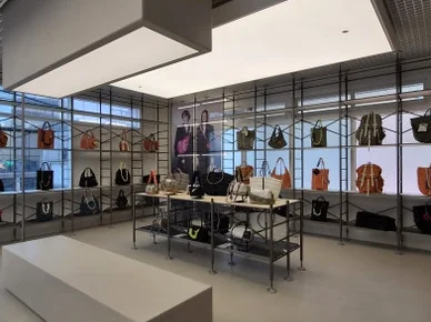 Wide interior perspective of Topologie store with bags on display, a long white bench, and illuminated ceiling panels - ソウルの森に誕生した Topologie 韓国初フラッグシップ：2026 SS ‘The Starbound’ の世界 🧭