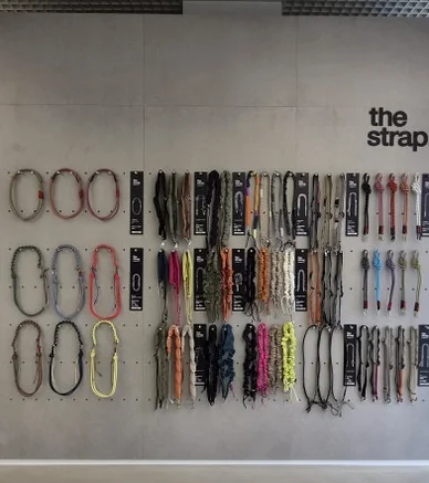 Wall display of various Topologie straps with 'the strap.' text on a modern concrete background - ソウルの森に誕生した Topologie 韓国初フラッグシップ：2026 SS ‘The Starbound’ の世界 🧭